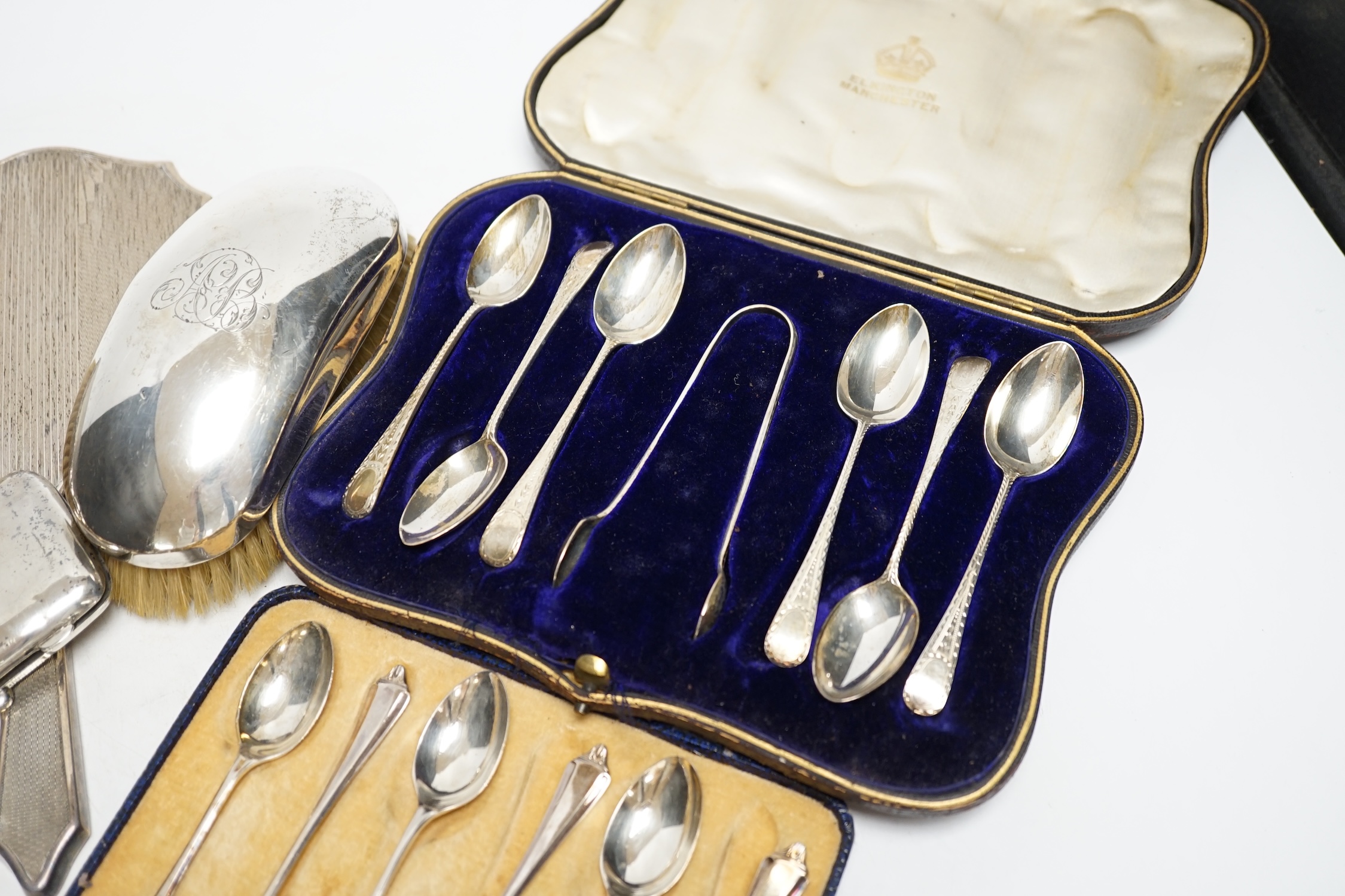 Two cased sets of six silver teaspoons, assorted silver mounted brushes and damaged mirror and a silver cigarette case.